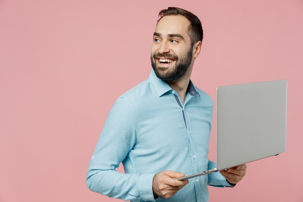 a person holding a laptop and smiling